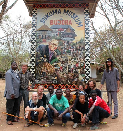 Dansegruppen Wanasecilias formands, Bujoras præst og gæster foran den flotte billboard som Sander Machombo har skabt i samarbejde med lokale kunstnere, bla. Simon Ndokeji. Foto: Mads Mchele Bischoff